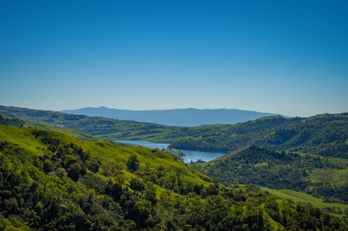 Free Stunning aerial view of lush green hills and a tranquil lake in Sunol, California. Stock Photo