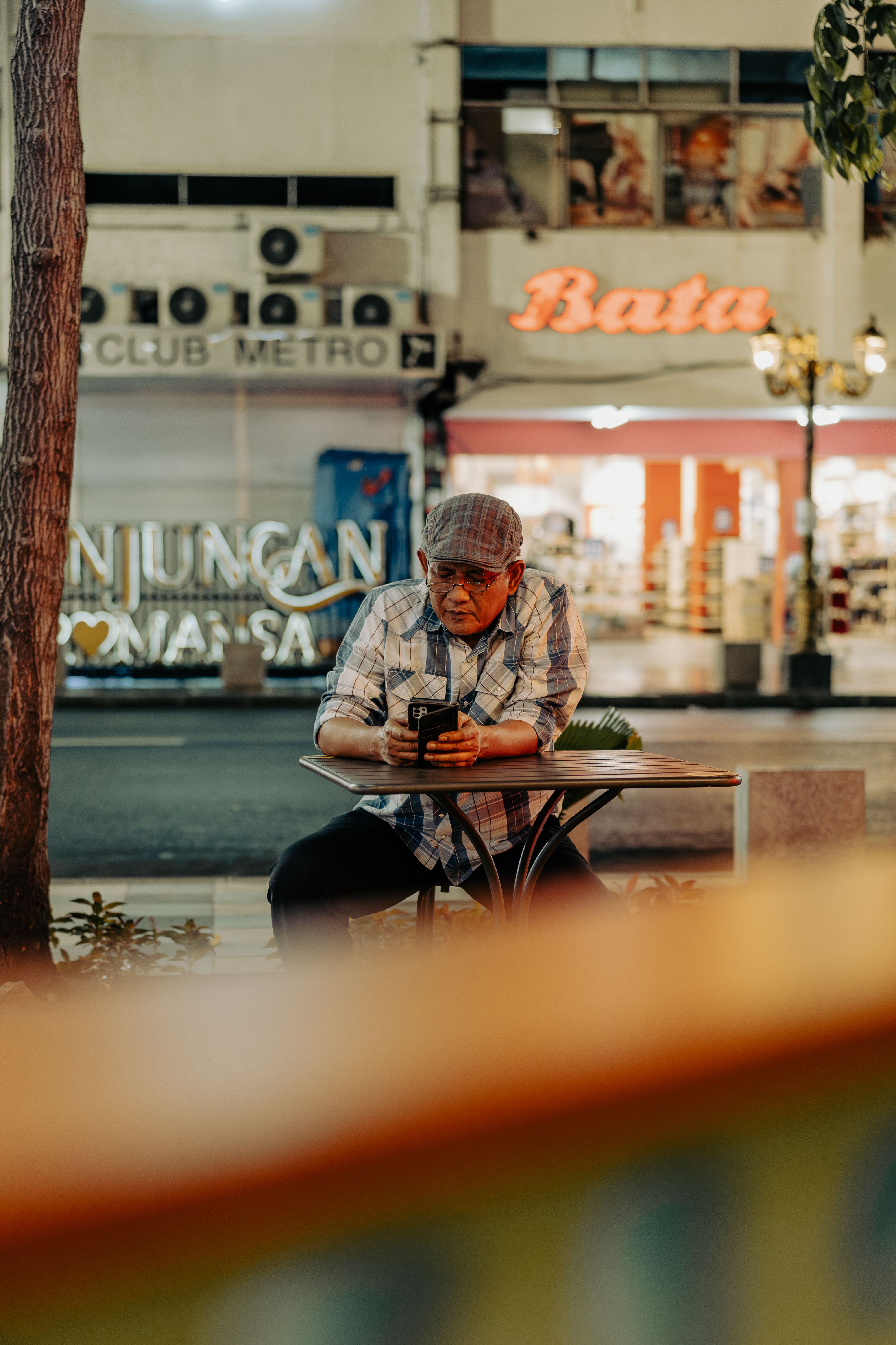 Elderly Man Relaxing at Outdoor Café in Surabaya