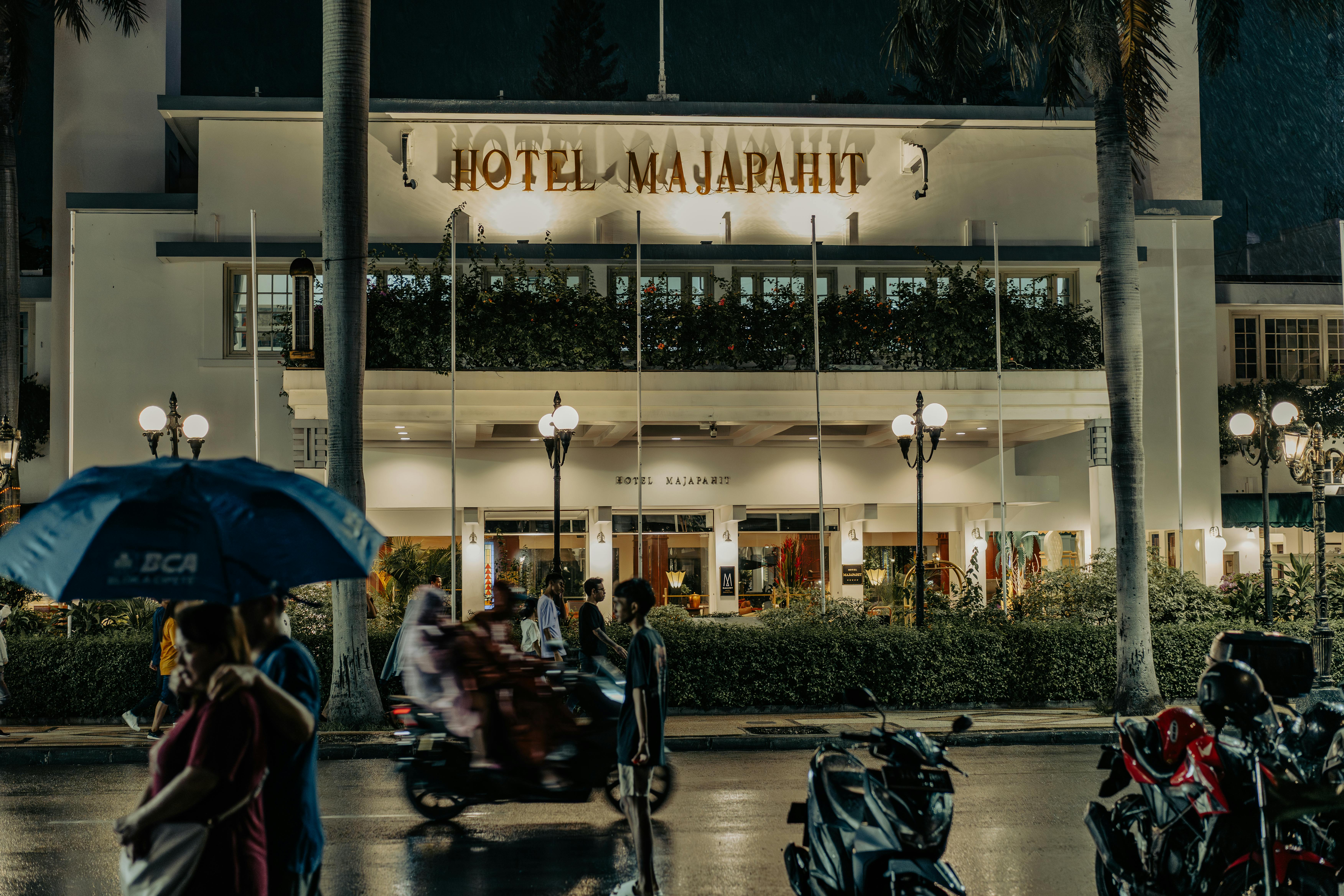 Bustling street scene outside Hotel Majapahit, Surabaya at night.