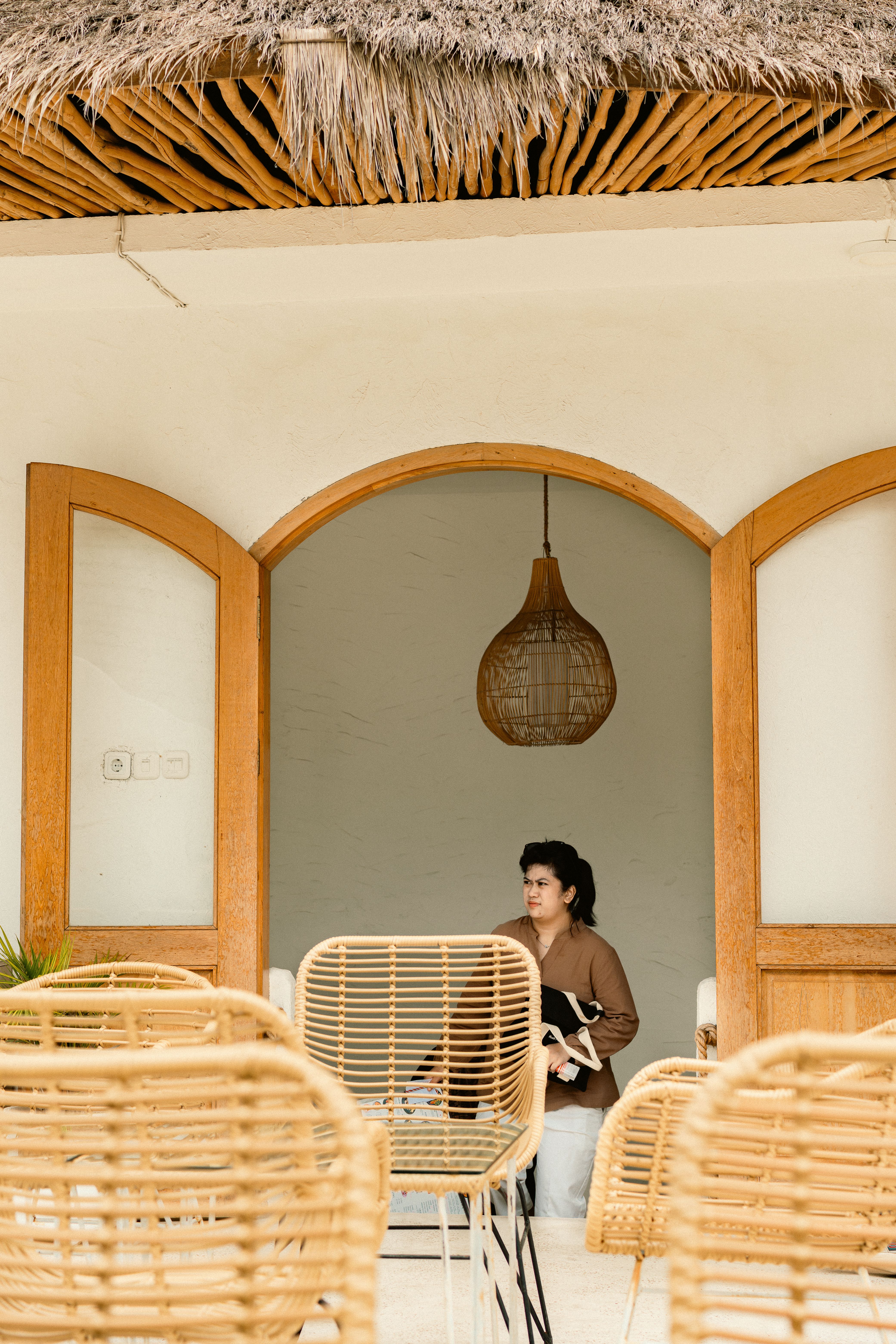 A serene café in Surabaya, Indonesia with wicker seating and a relaxed atmosphere.