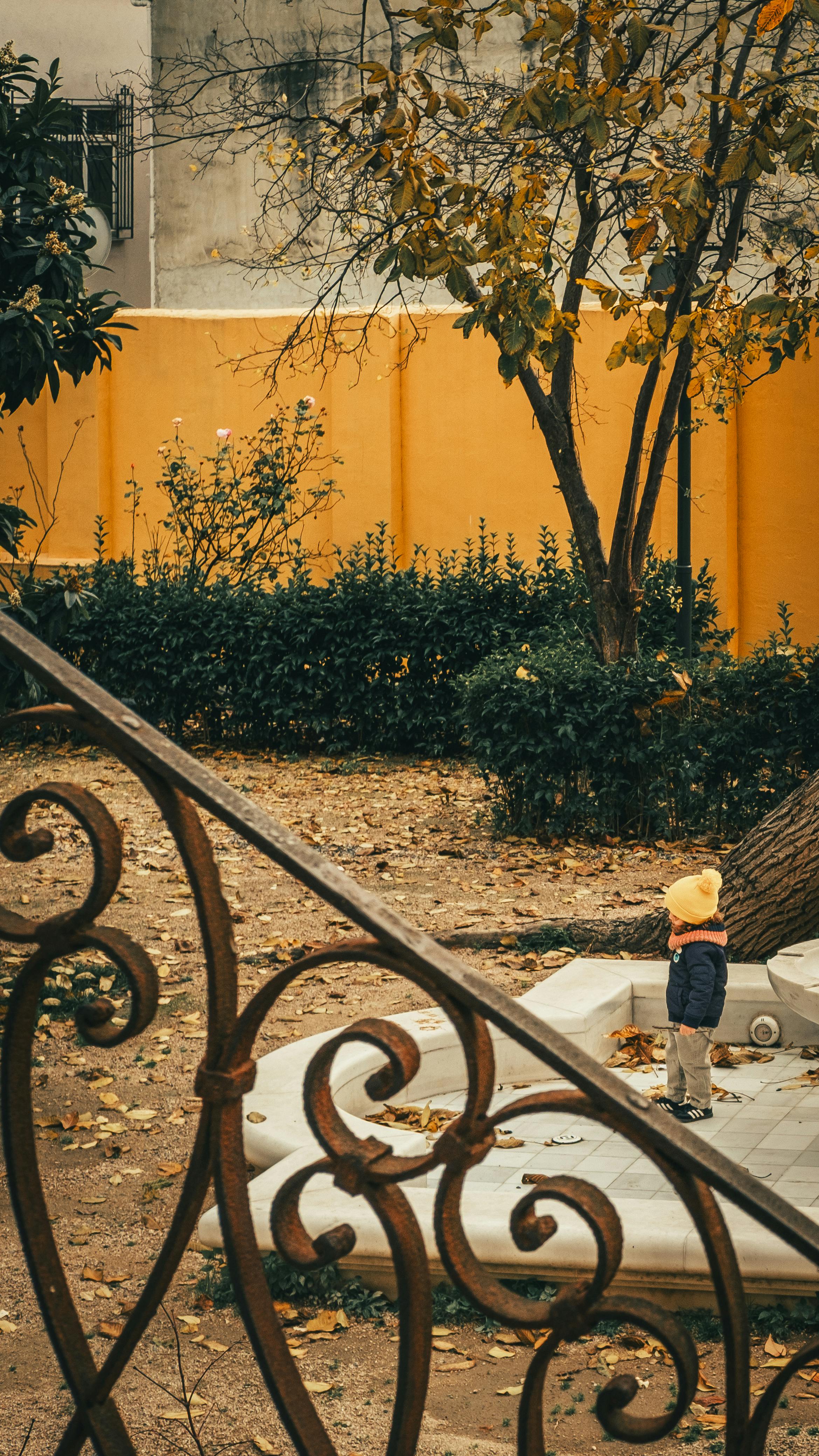 Gratis Un bambino con un cappello giallo è all'aperto in un parco in autunno. Ripreso con uno stile vintage e artistico, perfetto per immagini lifestyle e stagionali. Foto a disposizione