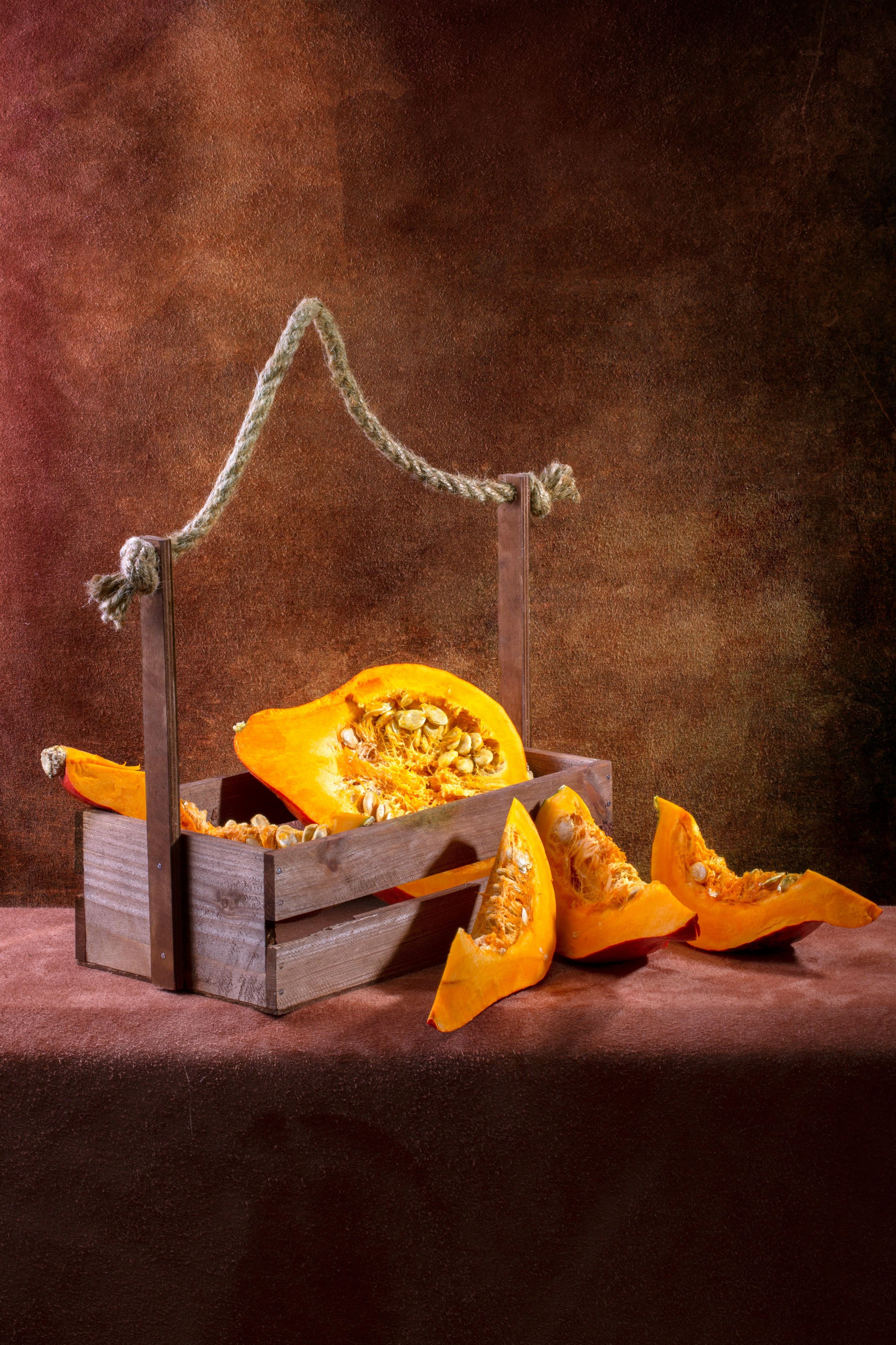 Miễn phí Tranh tĩnh vật mộc mạc sống động với hình ảnh quả bí ngô được cắt lát trong thùng gỗ. Hoàn hảo cho chủ đề mùa thu. Ảnh lưu trữ