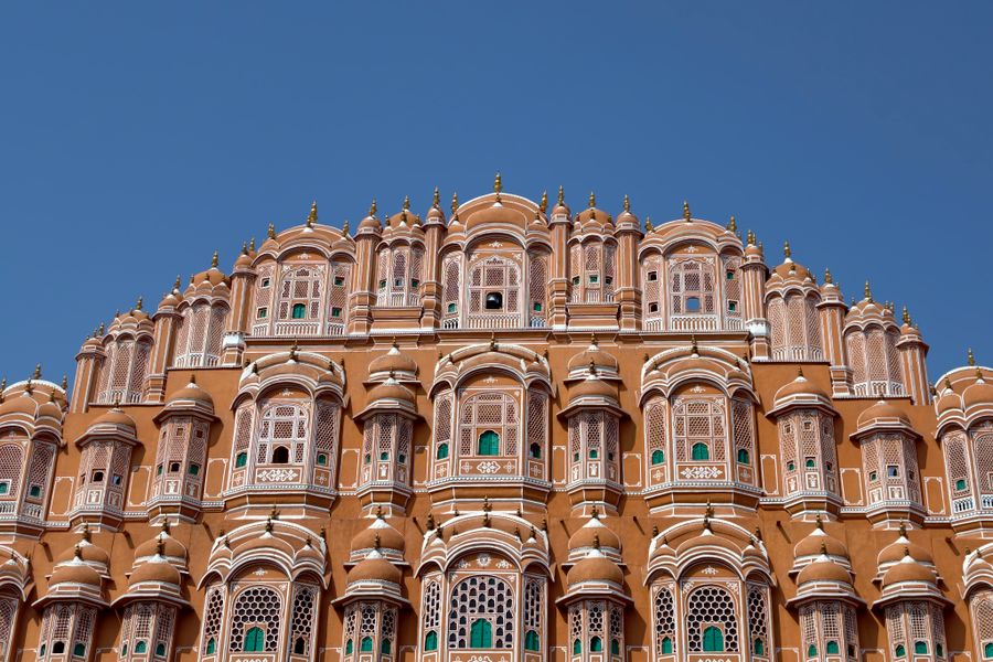 A stunning view of Jaipur's iconic Hawa Mahal with its intricate architecture against a clear blue sky.