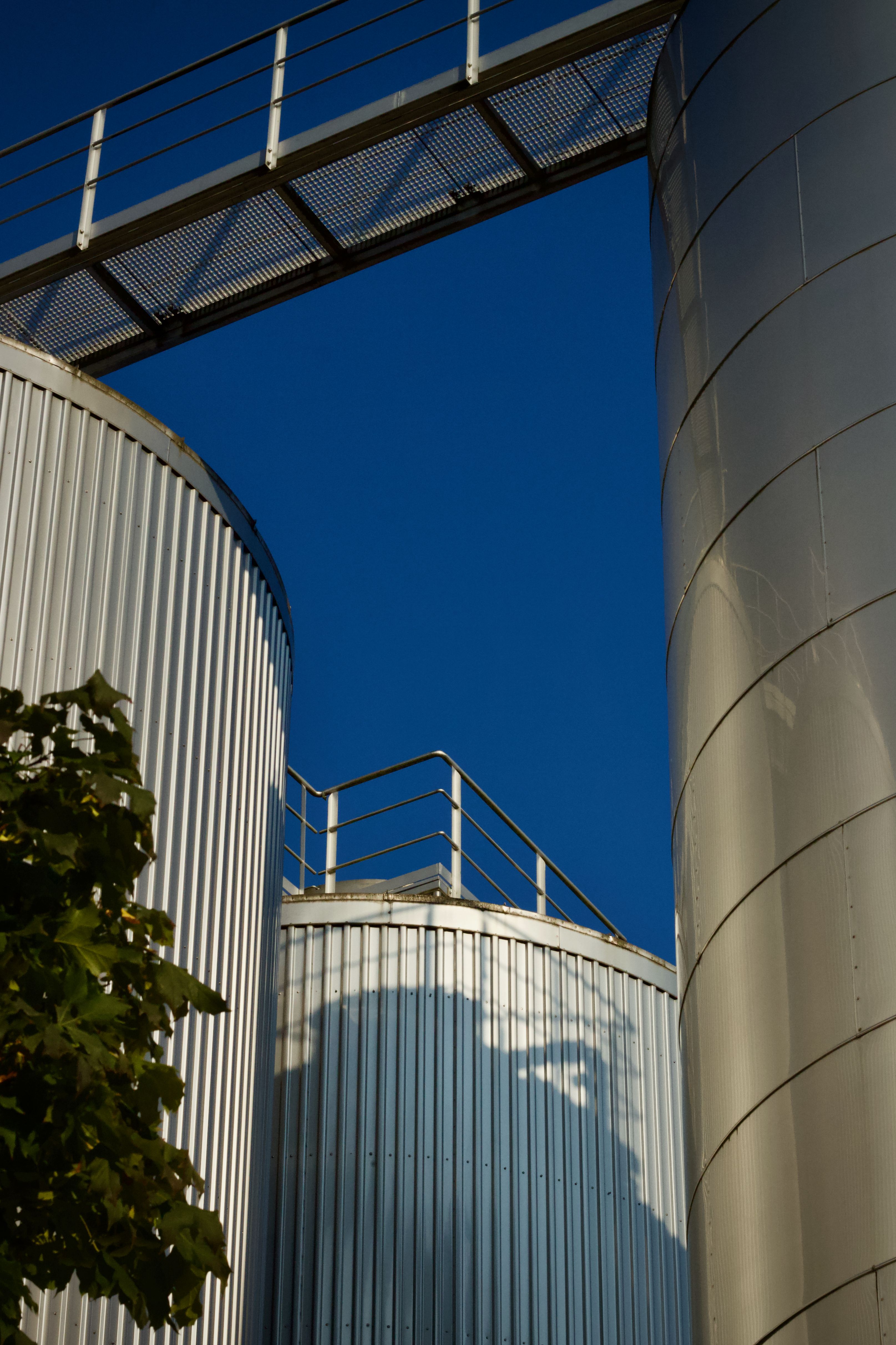 Modern Industrial Silos Against Blue Sky · Free Stock Photo