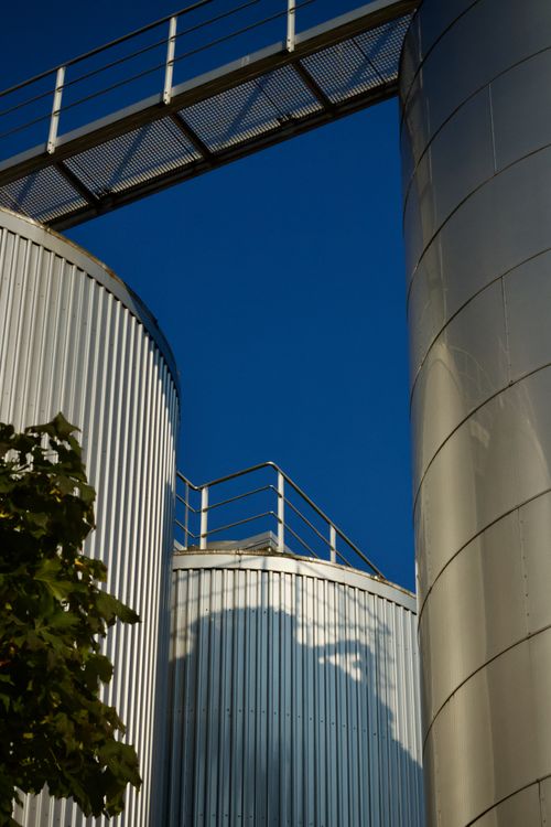 Free Close-up of industrial silos with a blue sky backdrop, showcasing modern architecture. Stock Photo