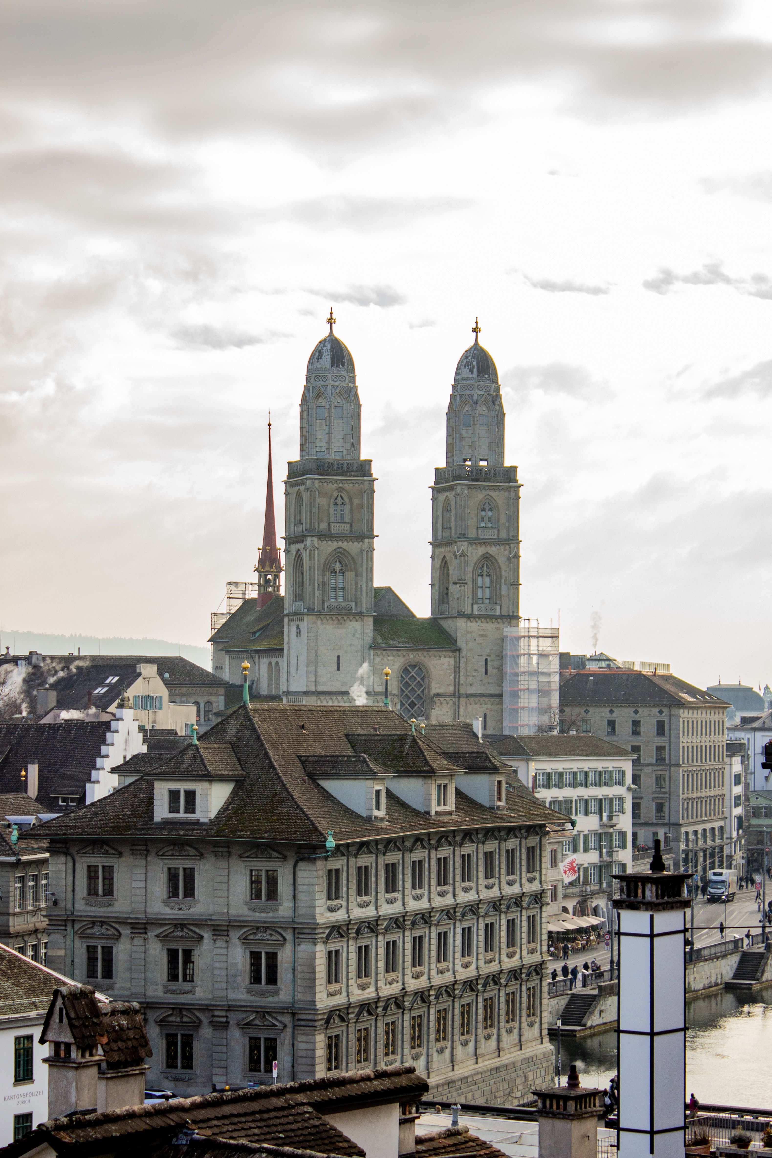 A scenic view of Zurich's historic Grossmünster towers under a cloudy sky.