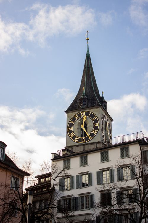 Free Iconic clock tower of St. Peter's Church against a clear blue sky in Zurich, Switzerland. Stock Photo