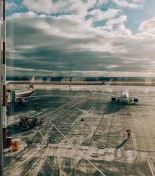 日出时分，机场霜冻的停机坪上，飞机静静停驻，构成一幅宁静的场景