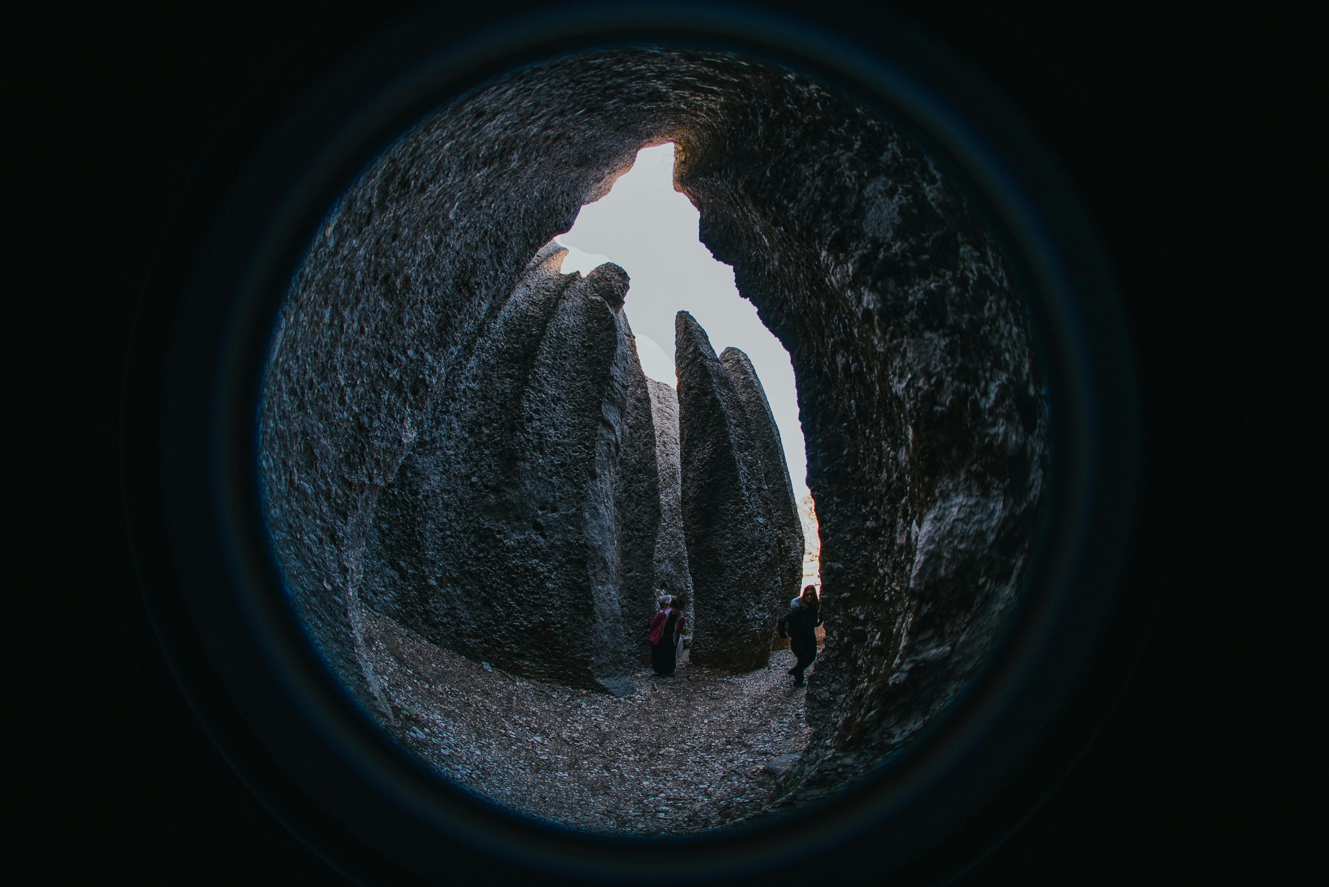Free Fisheye view inside cave with people exploring towering rock formations at day Stock Photo