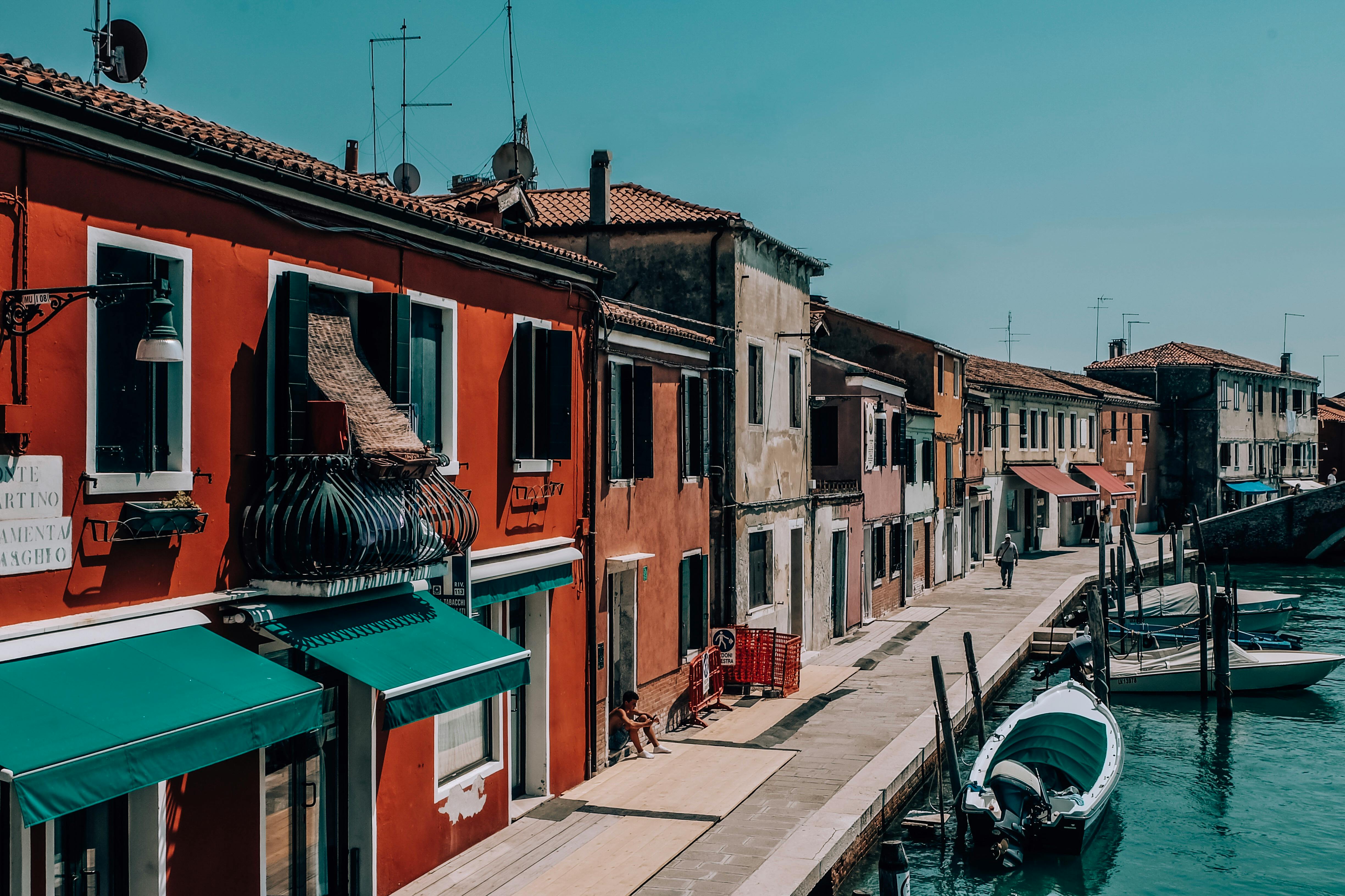 red and green houses beside body of water