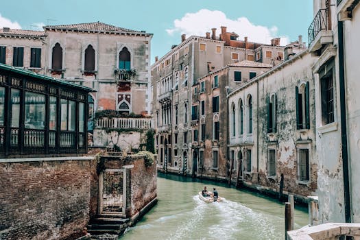 迷人的威尼斯运河景观，拥有历史建筑和阳光下穿行的船只，非常适合旅行爱好者