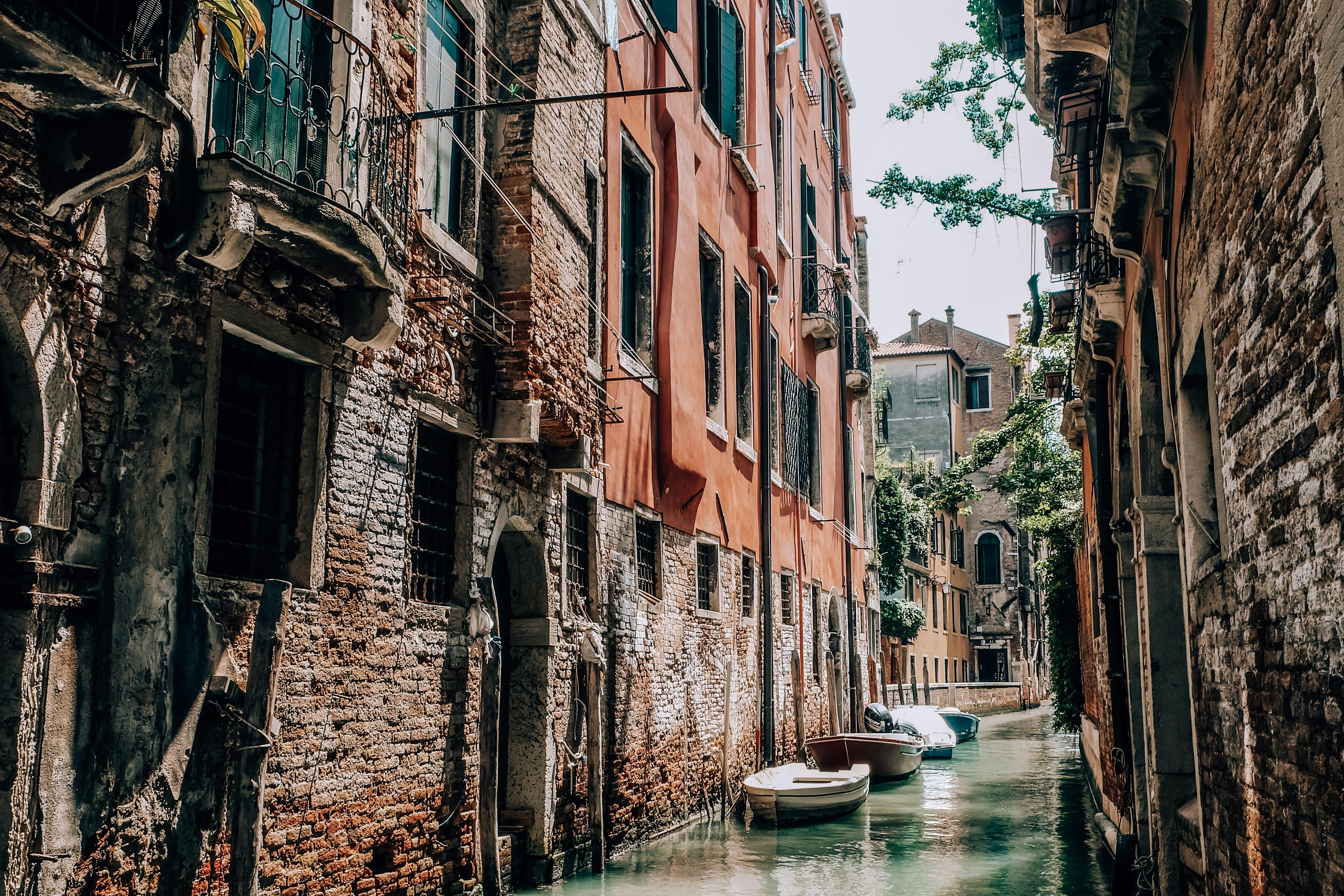 威尼斯运河风景如画，两岸矗立着历史悠久的砖砌建筑，水面上停泊着船只
