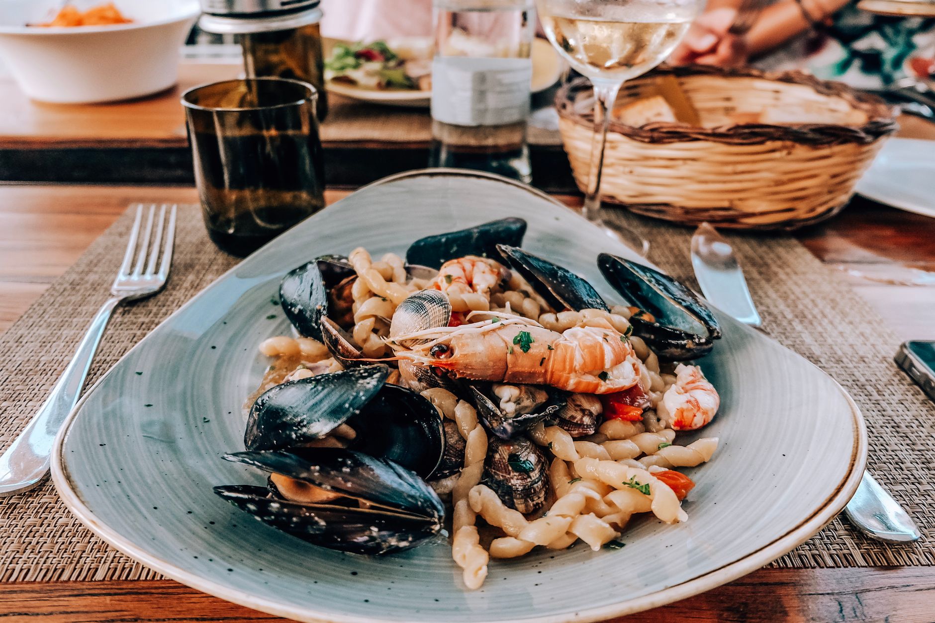 Pasta with mussels and shrimp in a bowl garnished with parsley