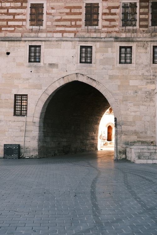 Free A historic stone archway with a cobblestone pathway inviting exploration of the past. Stock Photo