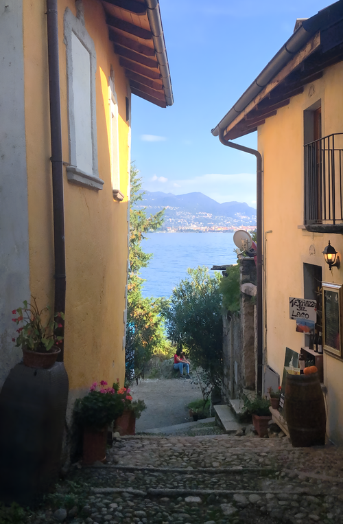 Free Picturesque alleyway in Feriolo, Piedmont with a view of Lake Maggiore and the Italian Alps. Stock Photo