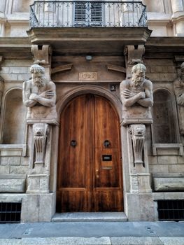 Ornate doorway with carved Atlantes in historical architecture setting. Classic European design.