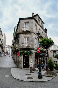 A corner building with balconies, shops, and street signs in a European city scene.