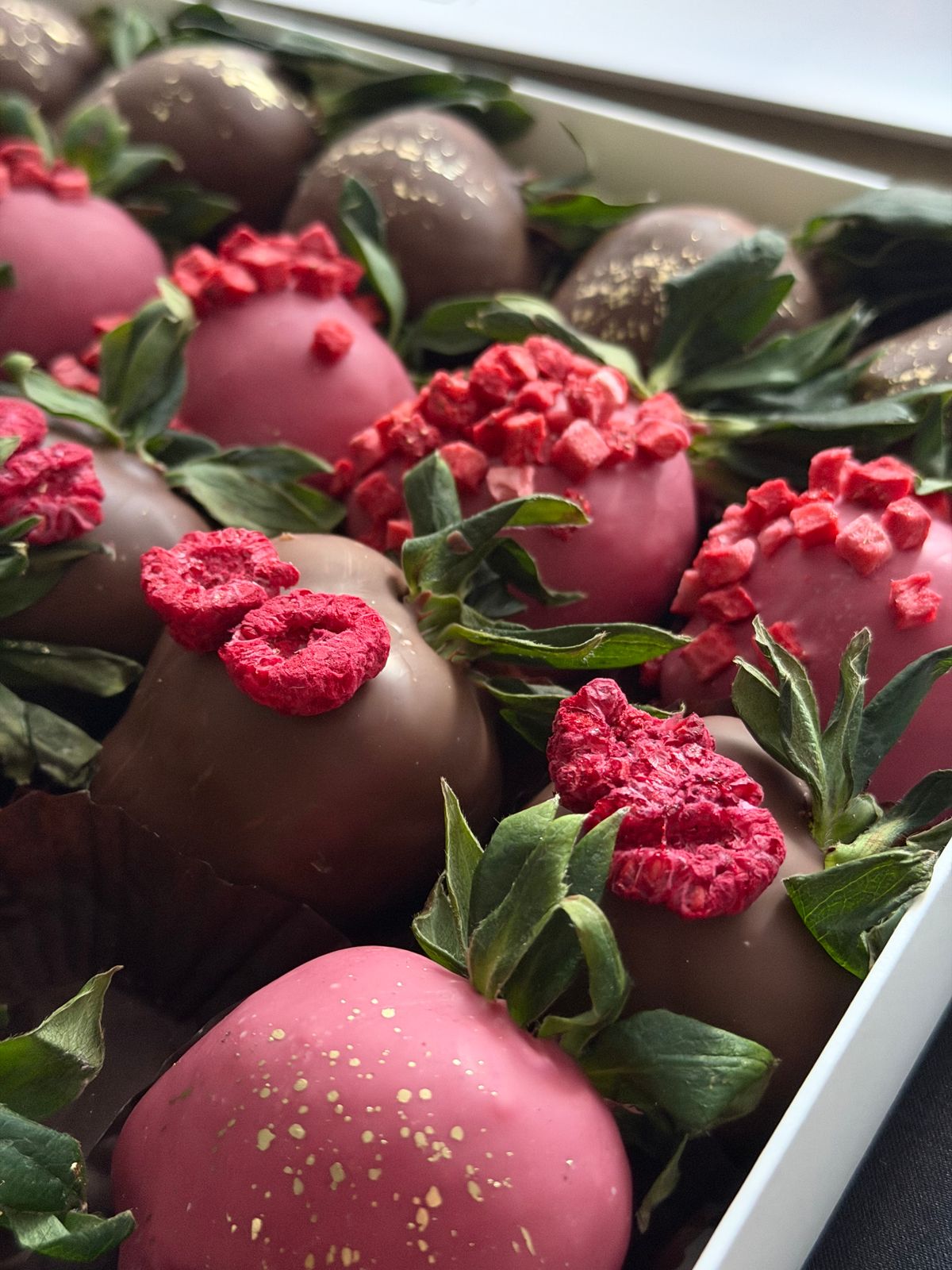 Close-up of chocolate covered strawberries with raspberries
