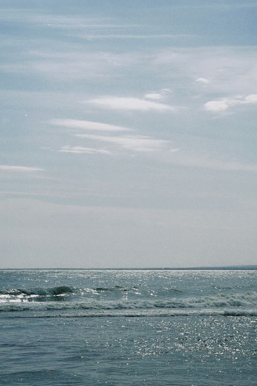 Free Tranquil ocean waves under a clear blue sky creating a peaceful seascape. Stock Photo