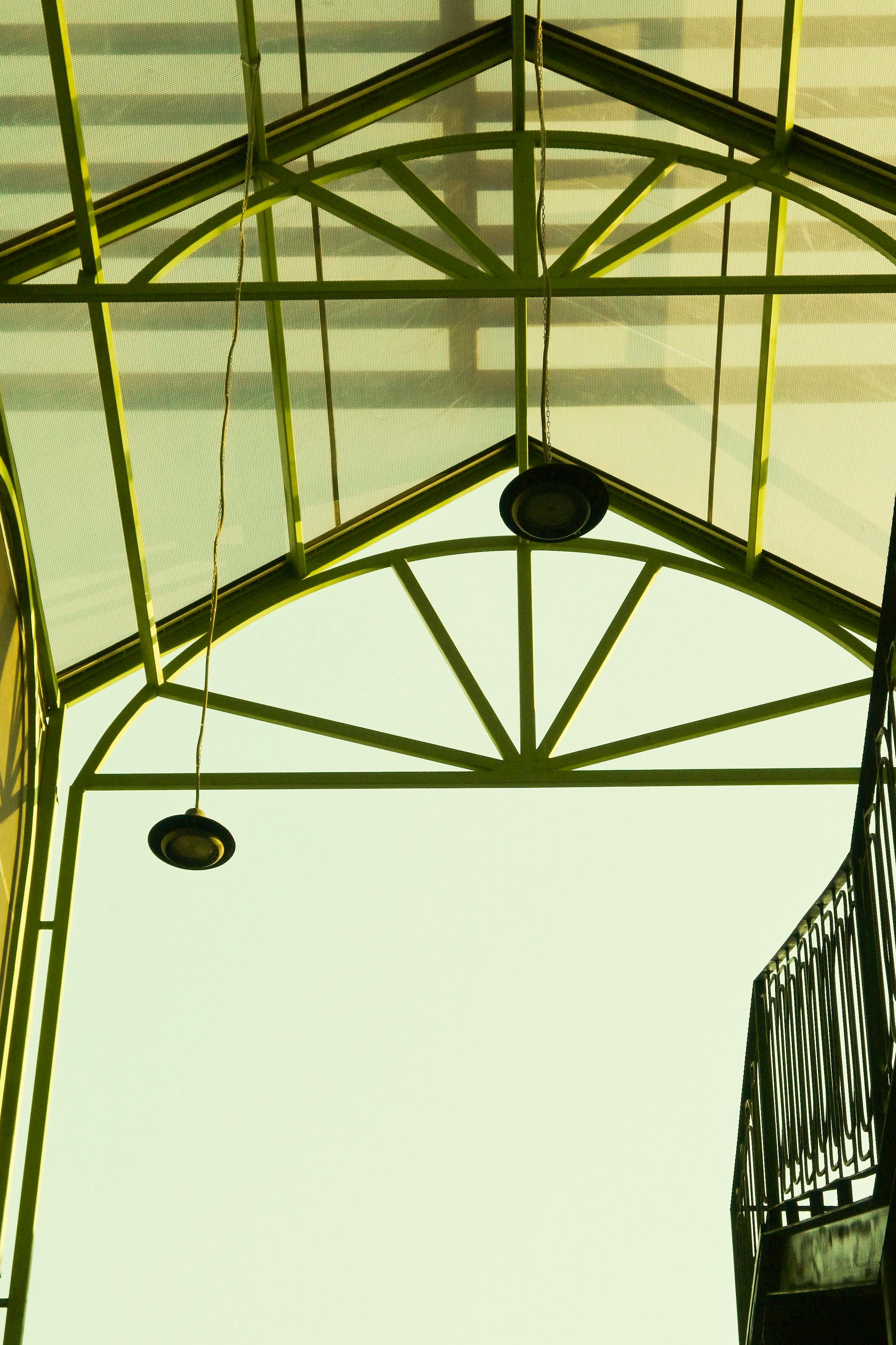 Gratuit Un design geometric al unei structuri de acoperiș din sticlă cu cadru și lumini metalice verzi. Fotografie de stoc