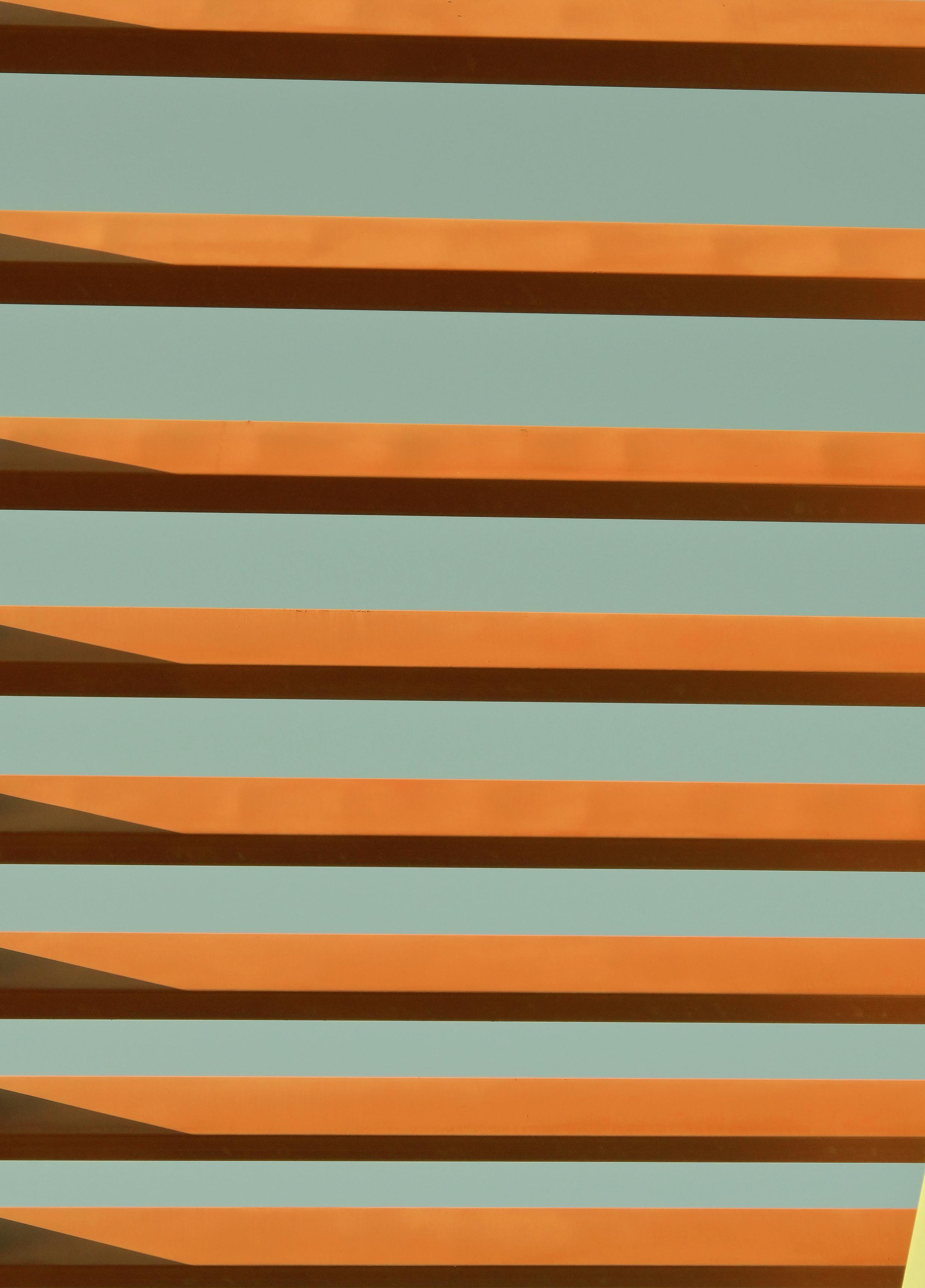 Ilmainen Silmiinpistävä abstrakti kuva, joka esittelee moderneja arkkitehtonisia linjoja lämpimällä väripaletilla. Kuvapankkikuva