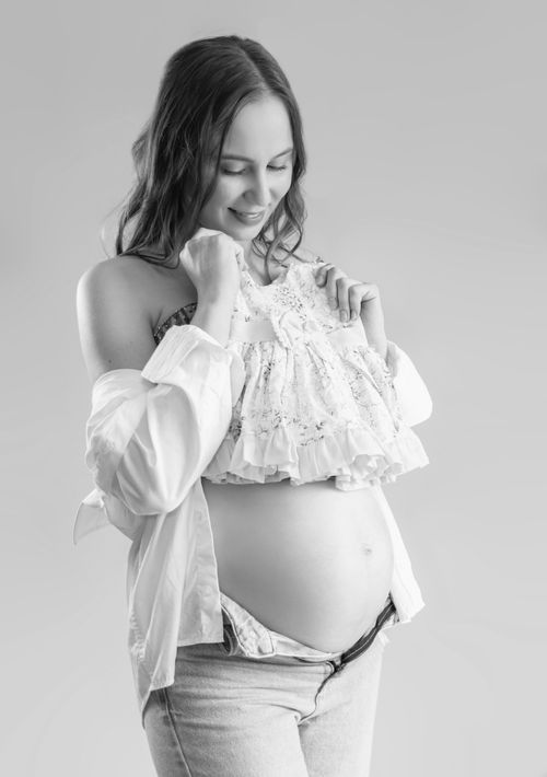 Free Elegant black and white portrait of a pregnant woman in a joyful pose. Stock Photo