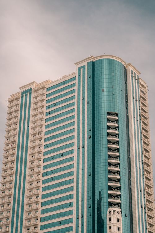 Free A striking modern skyscraper in the United Arab Emirates with unique blue and white facade. Stock Photo