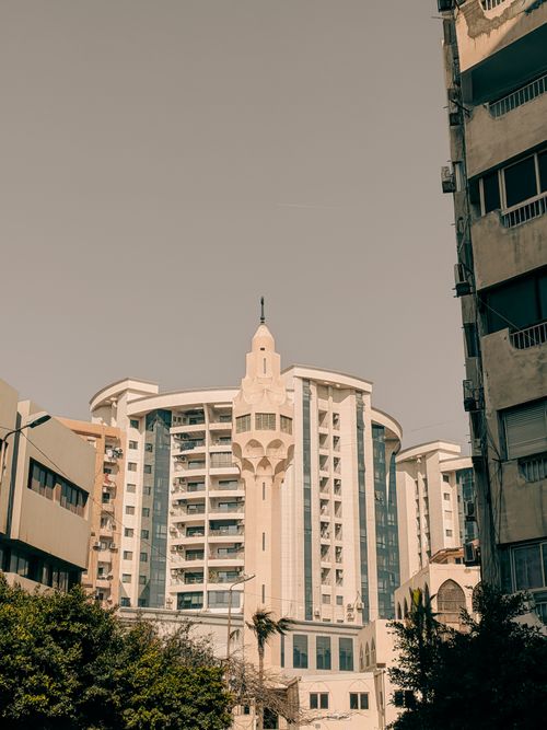 Free Tall contemporary building with classic elements amidst cityscape. Stock Photo