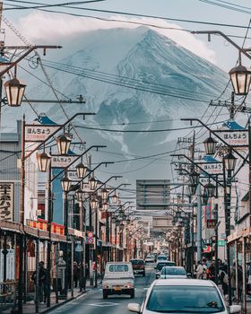 Bustling street scene with iconic Mount Fuji towering in the backdrop, capturing daily life in Japan.