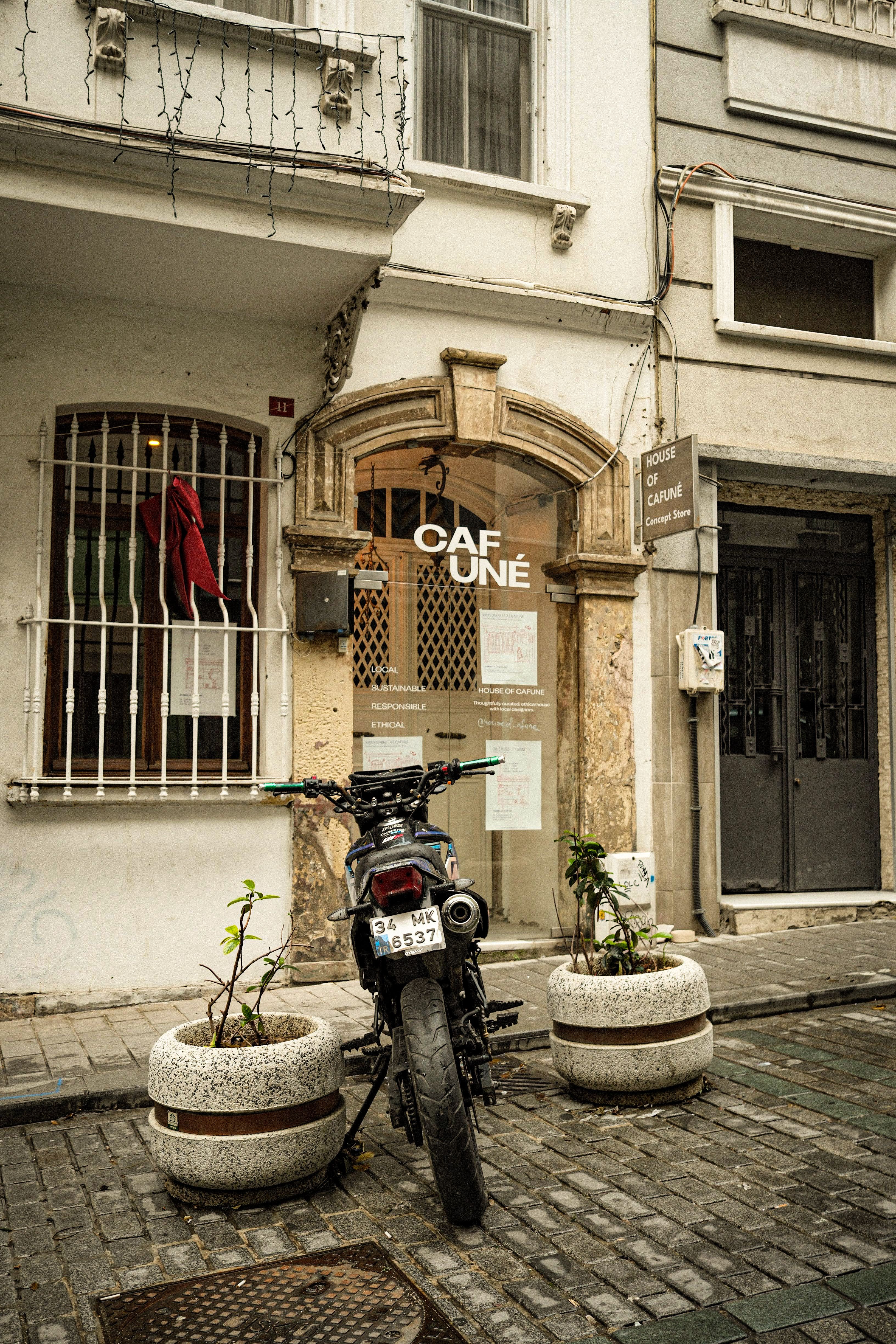 Motorcycle parked in front of a cafe on a European street cobblestone path.