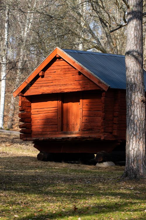 Free Rustic red wooden cabin in Jönköping, Sweden surrounded by trees. Stock Photo