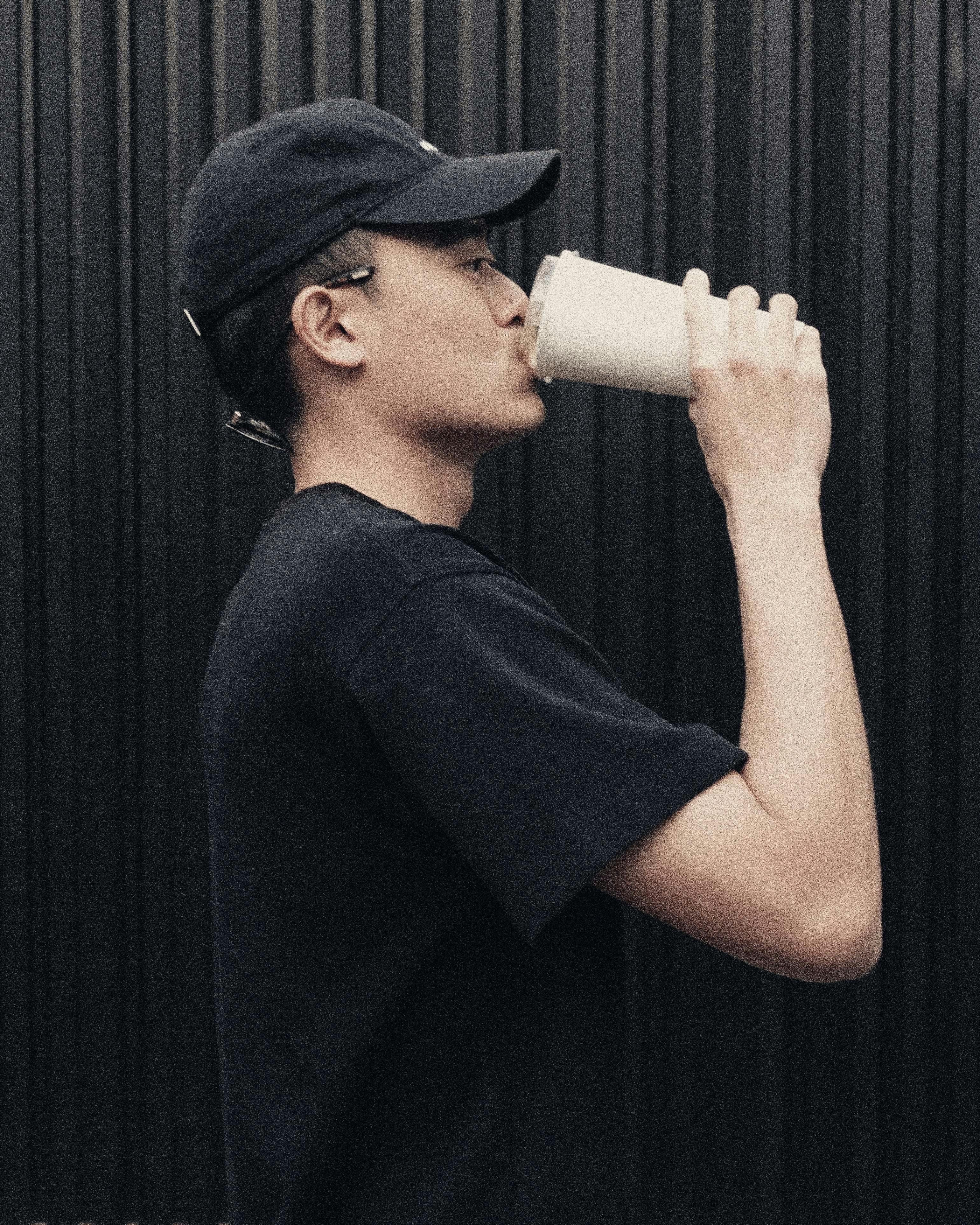 Young Man in Profile Drinking from Cup