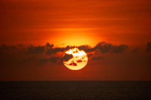 Stunning sunset over the ocean in Bali, Indonesia, with vibrant orange hues.