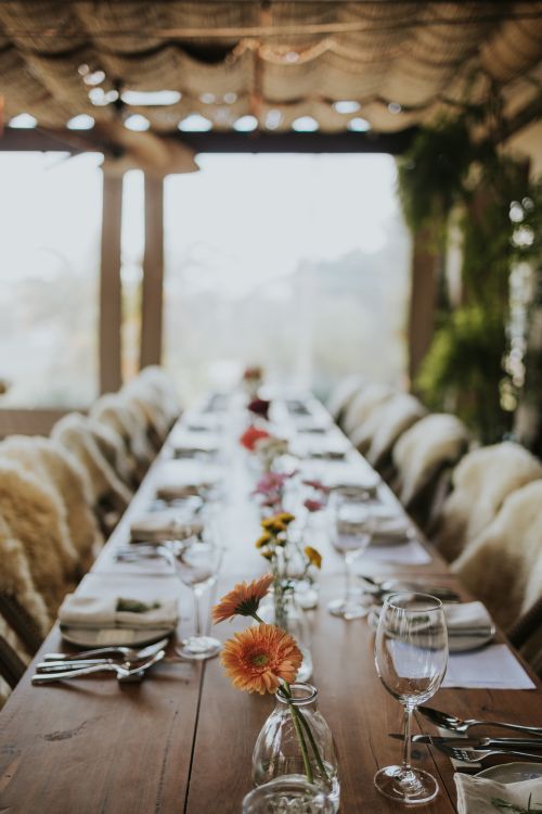 Free A beautifully arranged dining table adorned with flowers, ready for a special gathering. Stock Photo