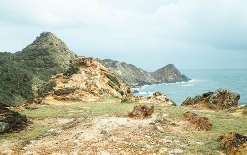 Free Explore the rugged coastal rocks meeting the ocean under a cloudy sky, perfect for natural exploration. Stock Photo