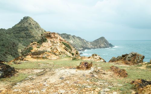 Free Breathtaking view of rocky cliffs by the ocean under a cloudy sky. Stock Photo