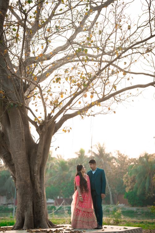 Free Romantic couple under a large tree in an outdoor setting, showcasing love and nature's beauty. Stock Photo