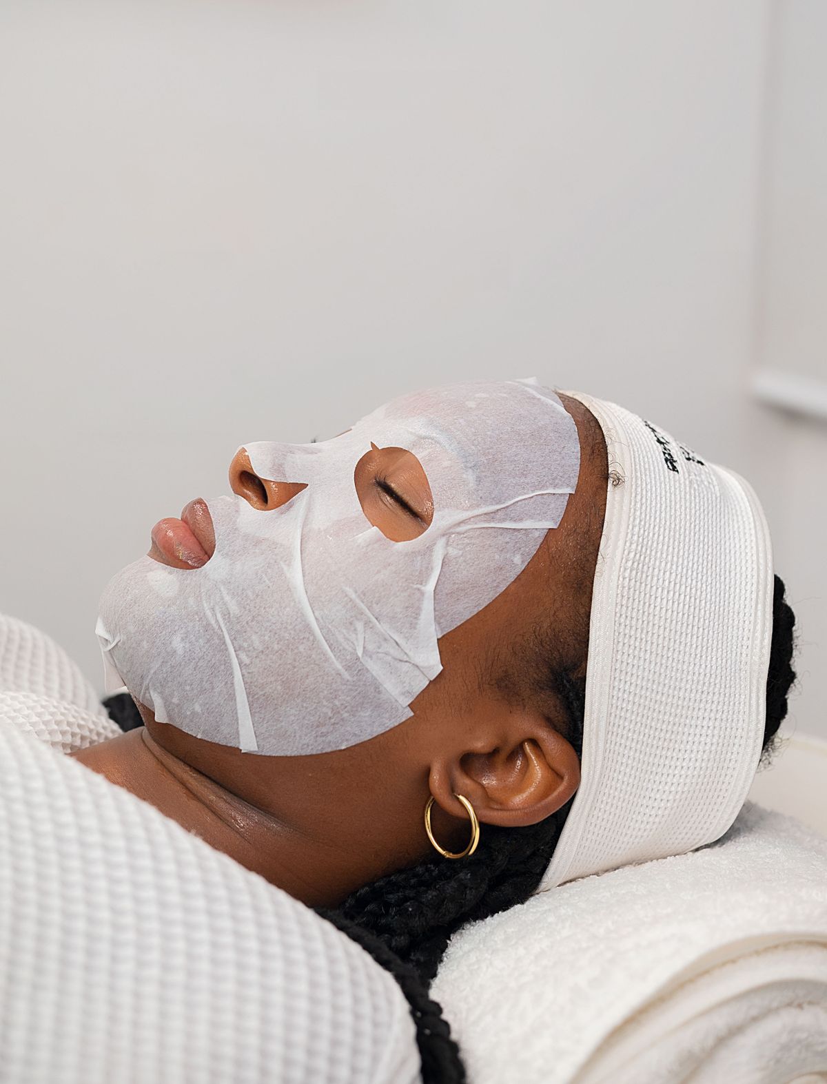 Black woman receiving a hydrating facial treatment in a spa