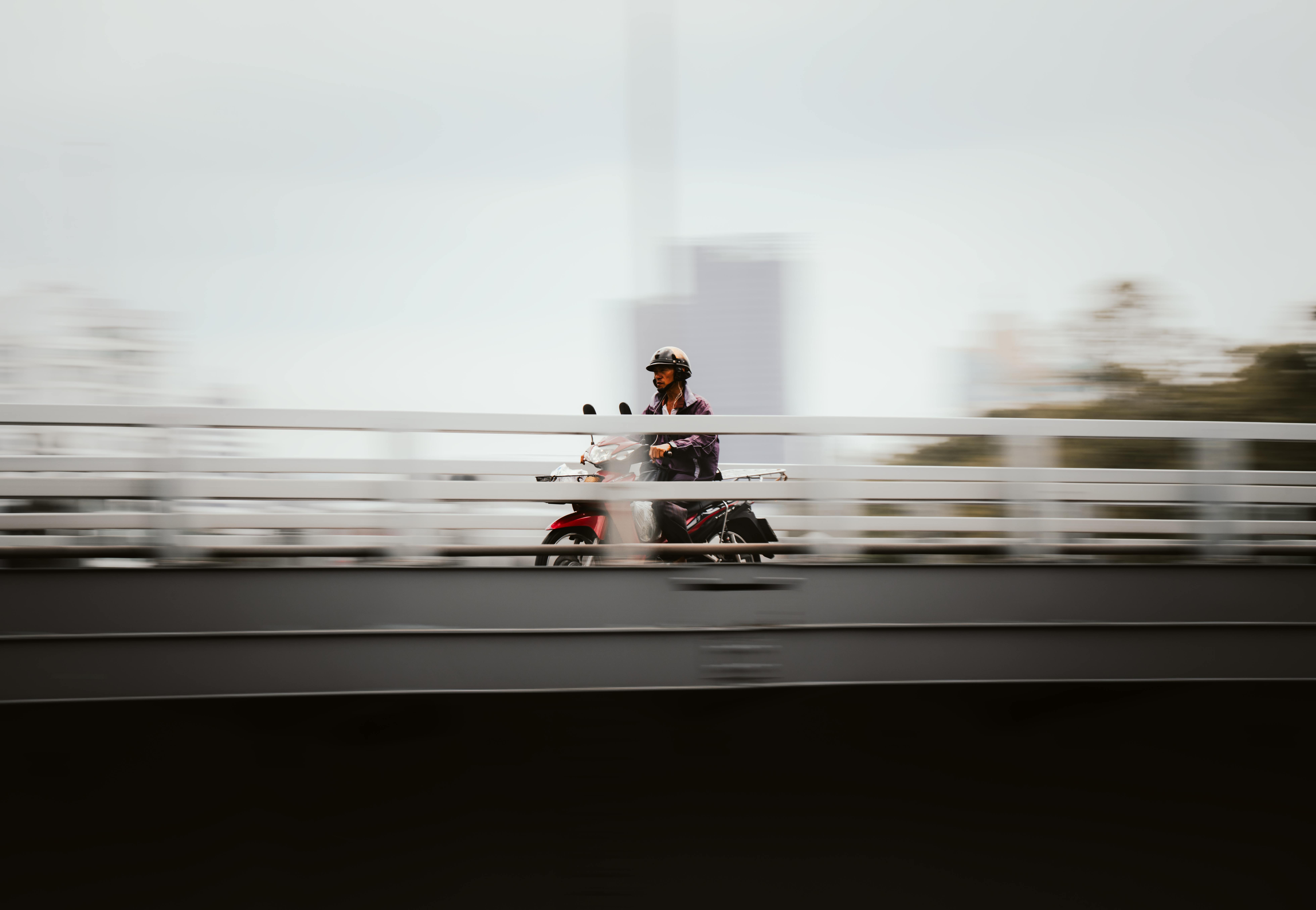 Gratuit Un motociclist traversează un pod din Bangkok cu un efect dinamic de estompare a mișcării. Fotografie de stoc