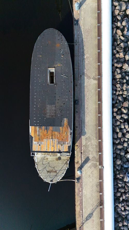 Free Aerial shot of an old boat docked at a pier in Jönköping, Sweden, highlighting rustic textures. Stock Photo