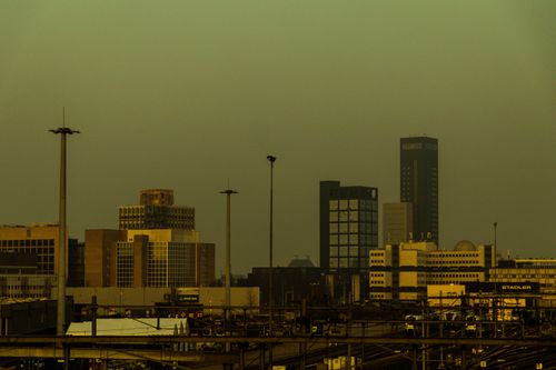 Free A dramatic cityscape view with buildings under a hazy atmospheric light, showcasing urban architecture. Stock Photo