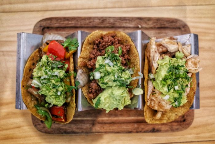 Trio of grilled steak street tacos with fresh toppings