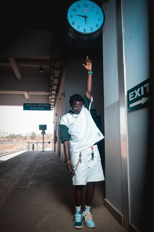 Free Young man posing stylishly in Abuja Metro Station under clock. Stock Photo