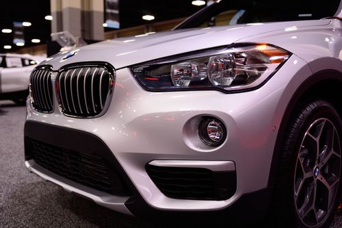 Free Close-up of a luxury car's front end showcasing its sleek design at an indoor auto show. Stock Photo