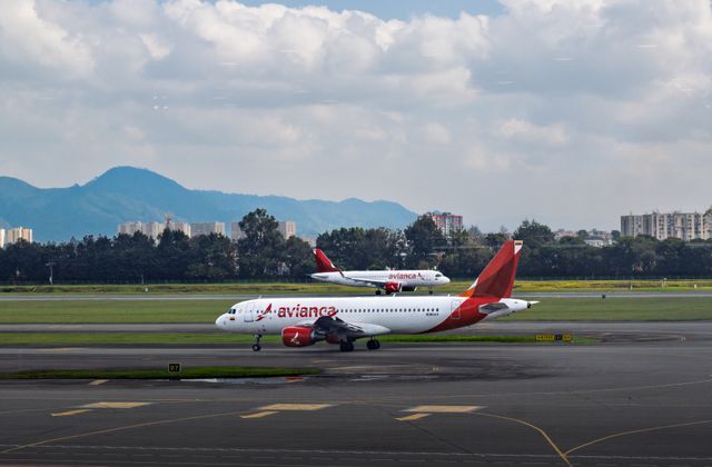 Avianca passenger aircraft on the runway at Bogotá, Colombia airport with city and mountains in background. — arriving in Bogotá