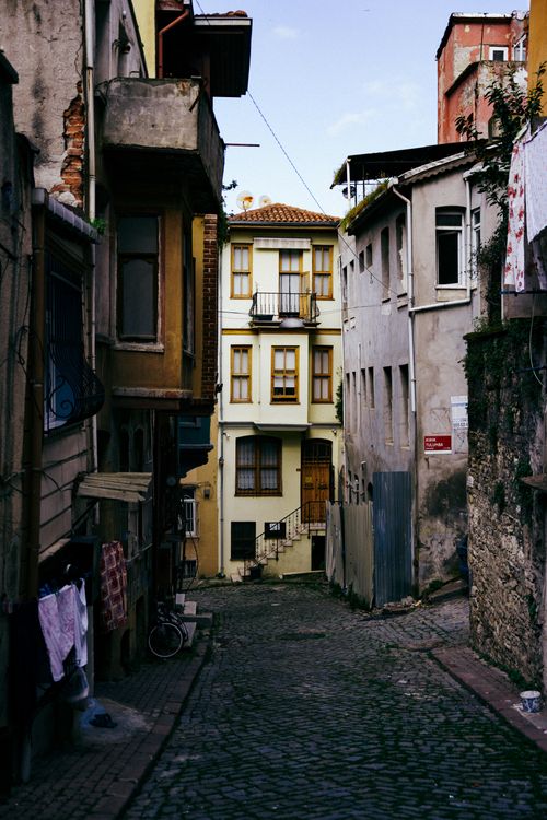 Free Charming narrow street in Istanbul lined with old buildings, vivid architectural details, and cobblestone path. Stock Photo