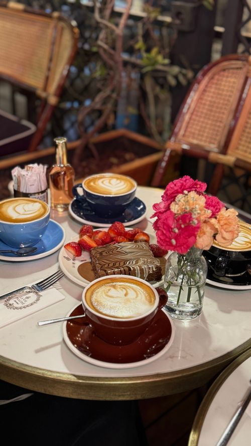 Free Savor cappuccinos and pastries at a stylish İstanbul café with vibrant flowers. Stock Photo