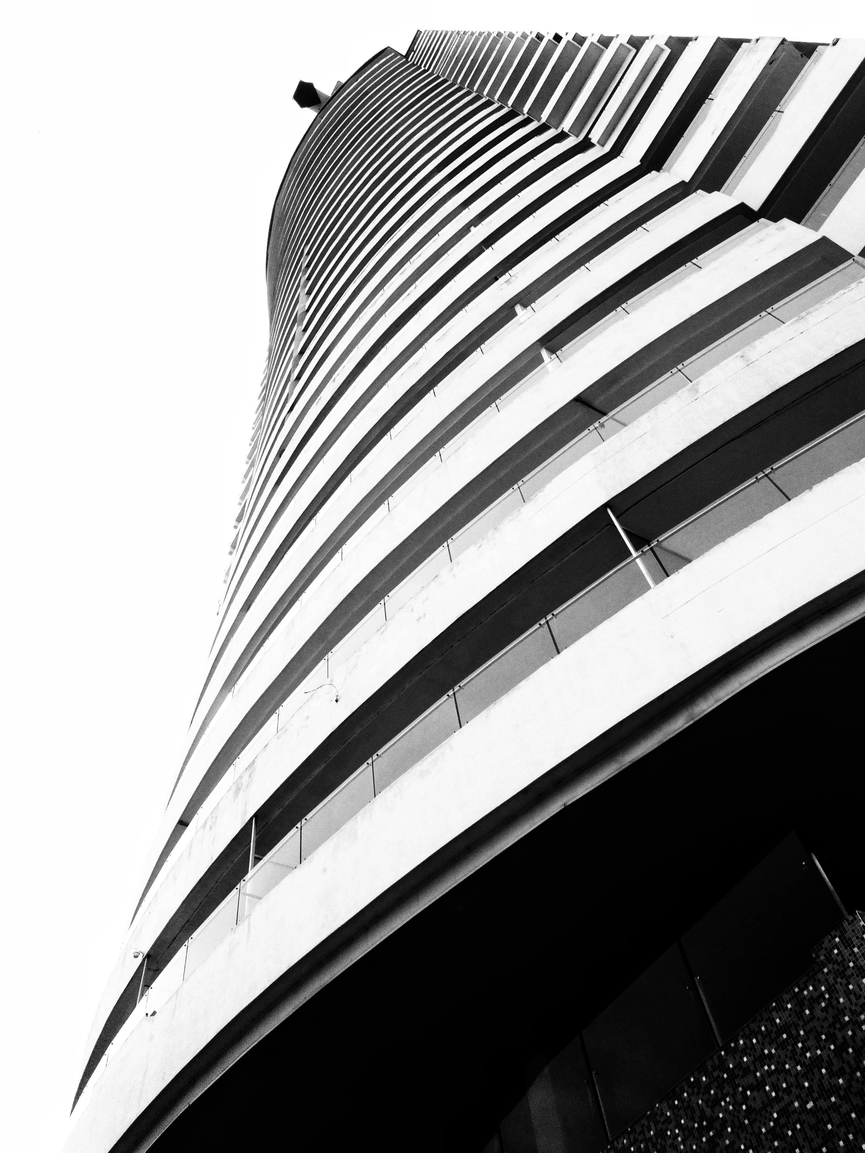 grátis Perspectiva dramática em preto e branco de um moderno arranha-céu, enfatizando sua arquitetura elegante. Foto profissional