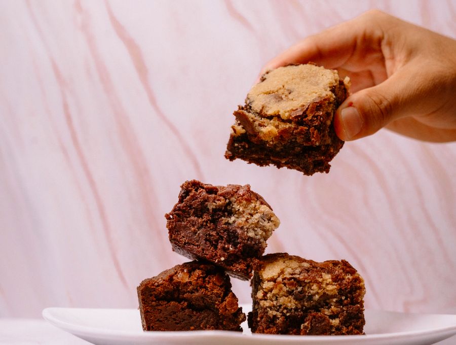 Stack of homemade brownies being picked up by hand