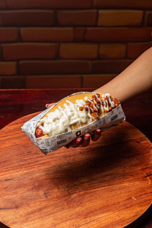 Free Gourmet hot dog loaded with condiments, perfect for a food blog or menu. Stock Photo